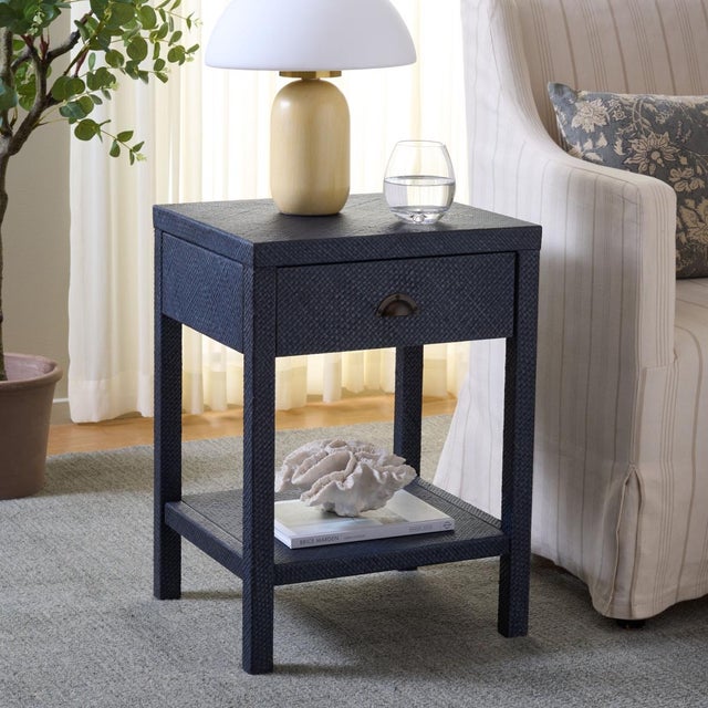 Introduce sophistication and functionality into your living space with the Apis Raffia 1 Drawer 1 Shelf Accent Table in...