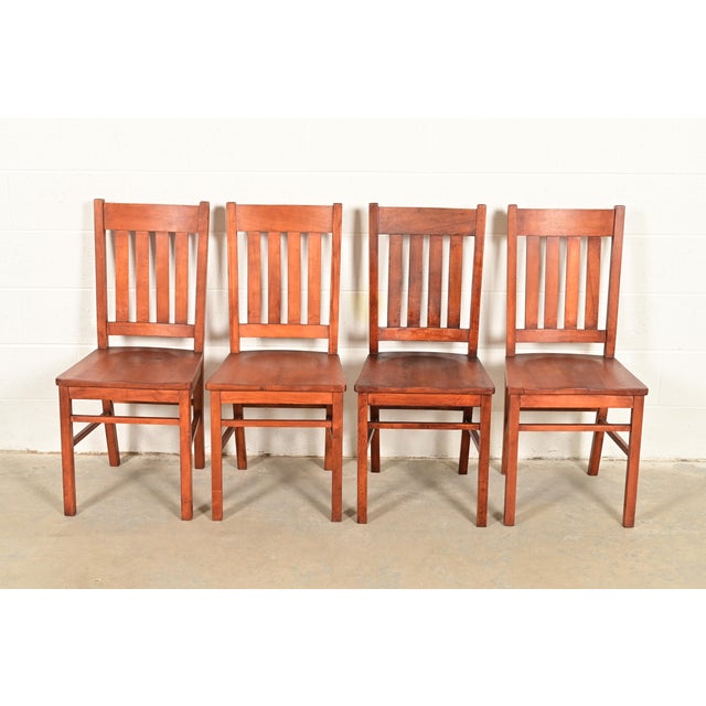 A gorgeous set of four Mission or Arts & Crafts period solid oak side chairs or dining chairs In the manner of Charles P....