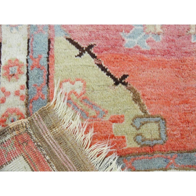 This charming antique Oushak rug is a fine example of early 20th-century Anatolian village weaving. The design is centered...