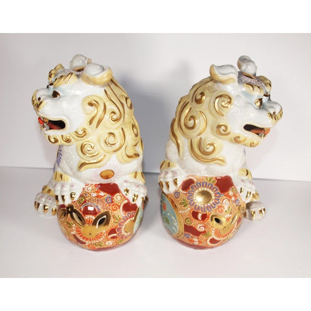 A pair of vintage Japanese Kutani Foo Dogs or temple lions. Cerami with bright colors and design. Foo Dogs are mythical...