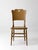 A late 19th century american cottage chair with a shaped crest rail, handhold cutout, bentwood side supports, and a turned...