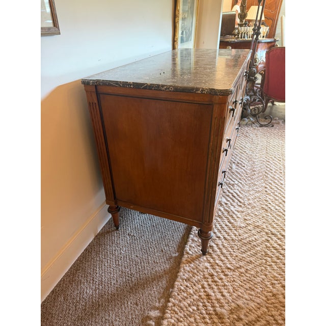 An exceptional, period-made 19th-century French Louis XVI style commode masterfully crafted with radiant burl walnut...
