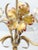 A whimsical vintage three-light chandelier with painted floral motifs. Three sculpted flowers, which are white with subtle...