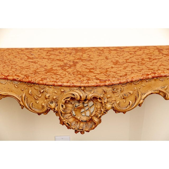 A fine and striking intricately carved console table with fine Louis XV o style, likely Italian. The console features a...