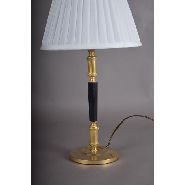 A sleek and sophisticated mid-century desk lamp of genuine architectural refinement — a polished circular brass base and...