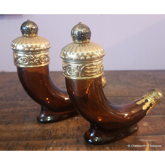 This is a good pair of vintage 1960s brown glass Avon after shave bottles in the shape of Viking Horns. Brass or gold...