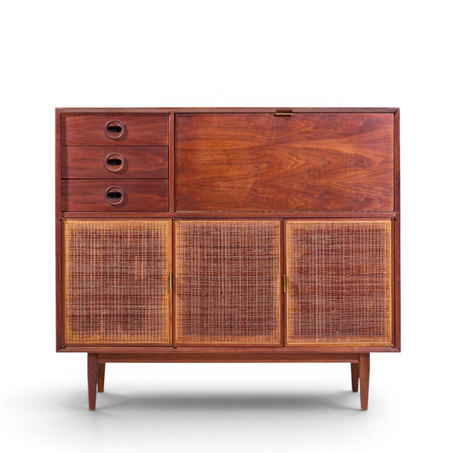 Jack Cartwright for Founders Mid Century Walnut and Cane Bar Cabinet This bar cabinet measures: 52 wide x 18.25 deep x...