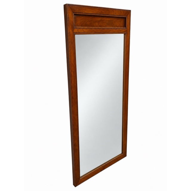 The Vintage Ethan Allen Cherry Wood Wall Mirror is a traditional rectangular mirror with a brown wooden frame, standing at...