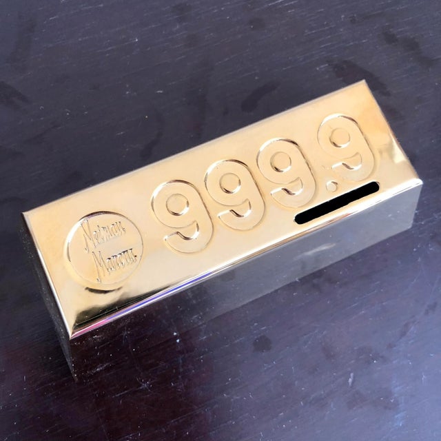 A Neiman Marcus gold bar style coin bank or paperweight. Like new condition with original gift box and tissue paper.