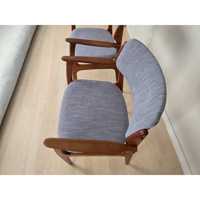 Pair of authentic Danish Modern teak armchairs made in Denmark, circa 1960s. These beautifully crafted chairs showcase the...