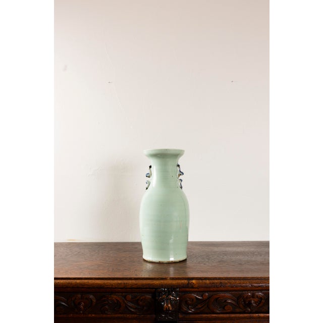 This Antique Chinese Celadon Vase decorated with butterflies and florals is a magnificent piece likely from the Qing...