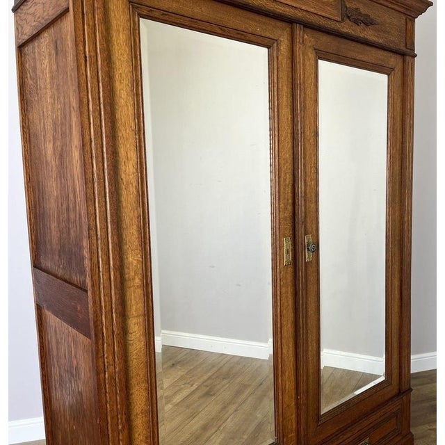 This elegant Antique French wardrobe showcases timeless craftsmanship with a warm oak finish, polished mirrored doors, and...