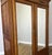 This elegant Antique French wardrobe showcases timeless craftsmanship with a warm oak finish, polished mirrored doors, and...