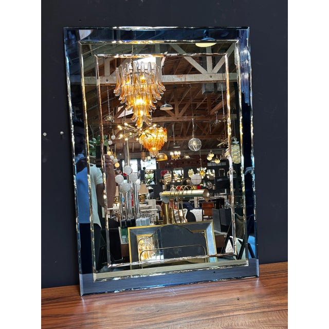 "A Mid Century Italian wall mirror from the 1980s, boasting a fully blue design that captures the bold and vibrant spirit...