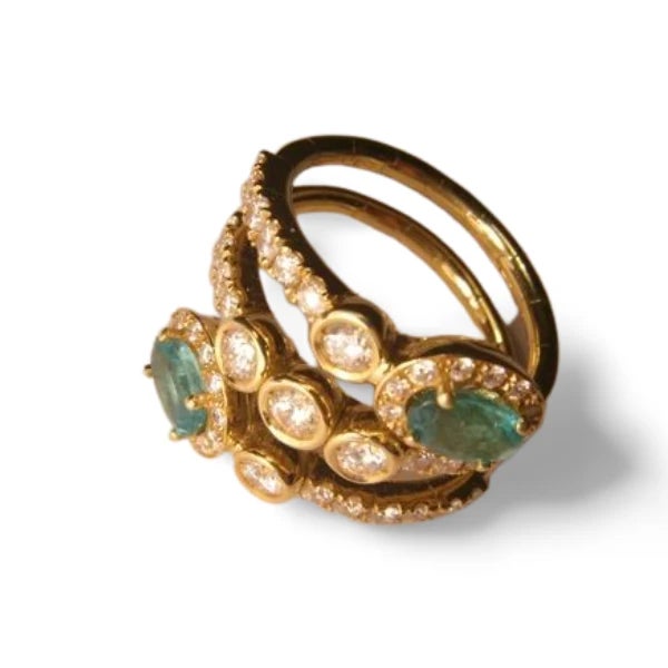18K Yellow Gold Emerald Diamond Bypass Cocktail Ring Band. This elegant ring features 2 natural oval emeralds totaling 0.9...