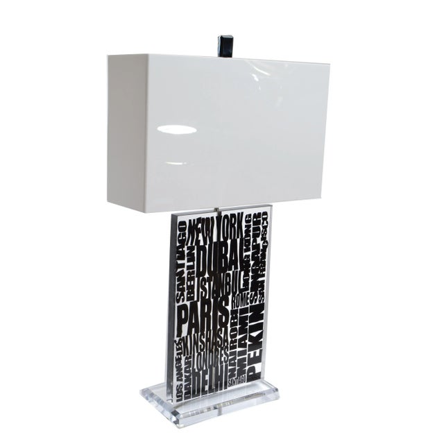 Super cool modern Lucite table lamp with white acrylic shade. The core is transparent with famous cities written out....