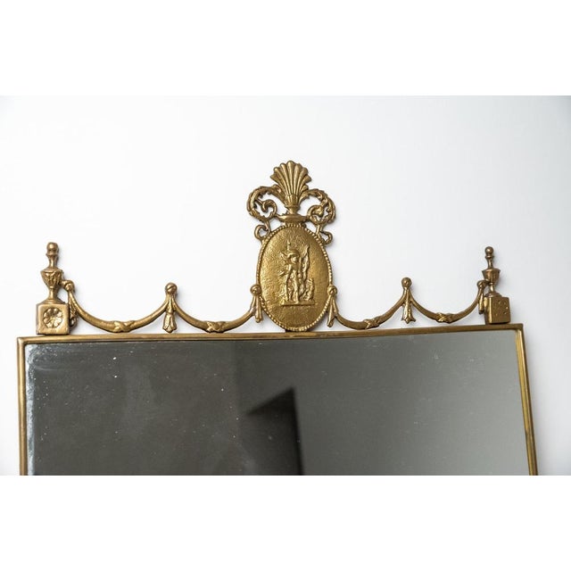 Made in Italy brass mirror, 1960s. Elegant 1960s brass wall mirror with Baroque-style selvage.