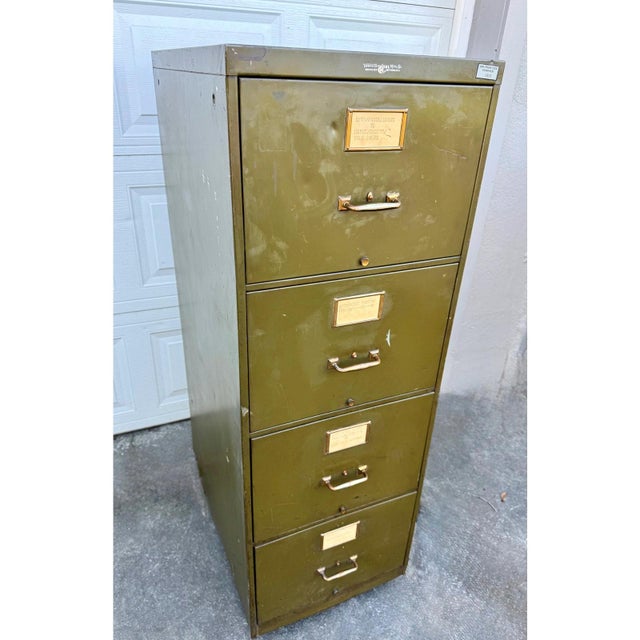 A substantial vintage five-drawer steel filing cabinet by Yawman & Erbe Mfg. Co., finished in an olive green tone with...