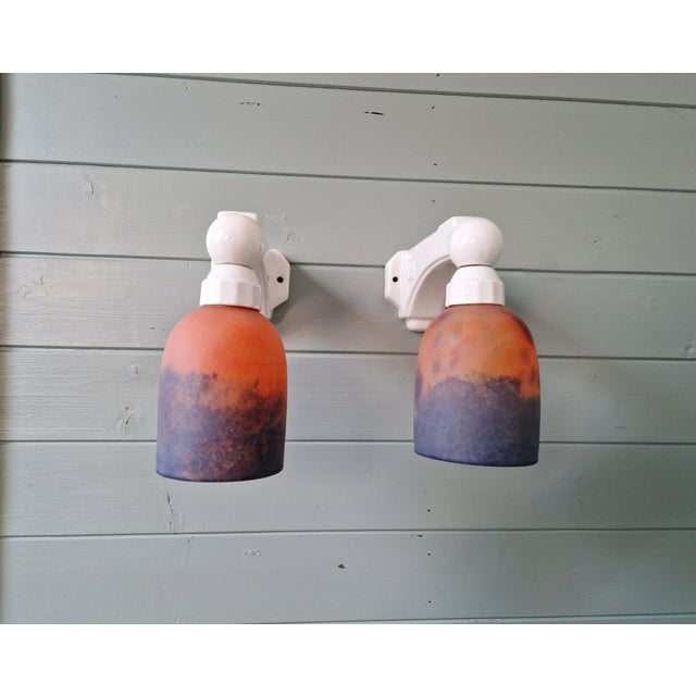 Pair of Art Deco wall sconces from the 1930s in porcelain and frosted glass, predominantly in shades of blue and orange....