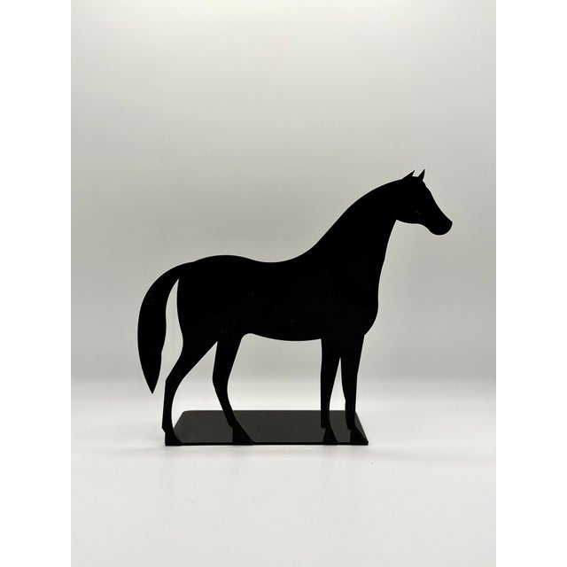 A striking pair of black metal horse bookends with a clean equestrian silhouette. Each bookend features a standing horse...