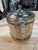 An elegant vintage silver-plated ice bucket featuring a distinctive basket-weave design. The cylindrical body is accented...