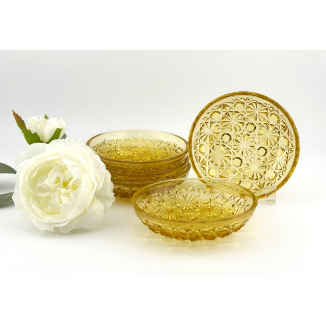 Amber glass individual butters, dating to the early 20th century. Made of pressed glass in the Daisy & Button pattern,...