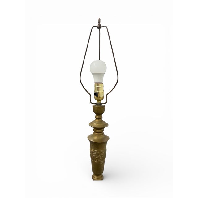 A tall solid brass floor lamp with a classic turned form and naturally aged patina, lending warmth and quiet...