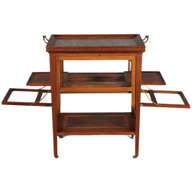 Antique serving trolley with automatic extension. Small shelves on the left and right slide out when the side flaps are...