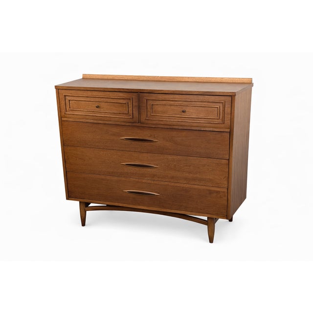 Description: Authentic vintage mid century modern Bassett “Mayan” highboy dresser featuring the signature carved center...