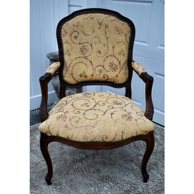Vintage (1980s) Bergere Chair has a French Style. The Frame is Wood. Carved Wood. The Fabric has a Swirly Floral Design,...