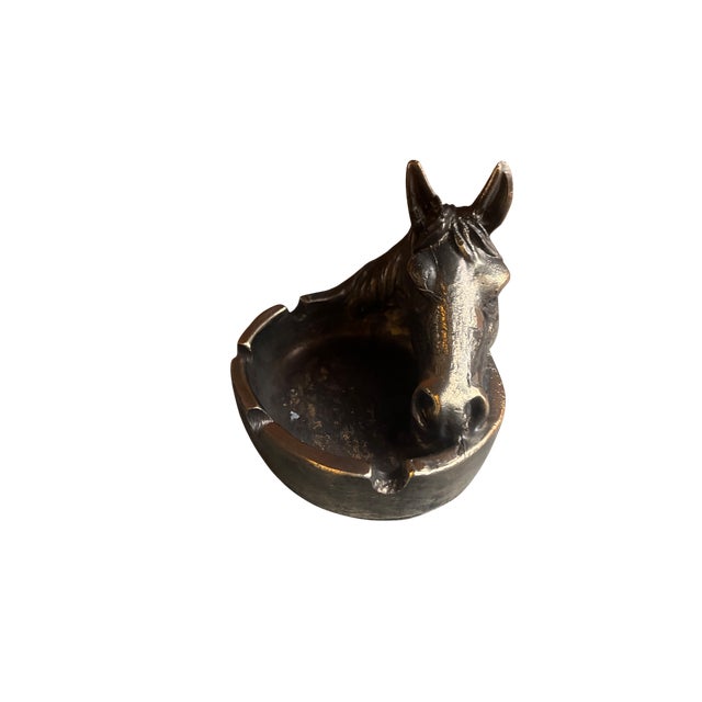 This piece features a detailed horse head sculpture that curves gracefully around the bowl. The finish is a deep, aged...