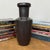 "About This Piece About This Piece This tall, architectural vase commands attention with its deep graphite glaze and clean...
