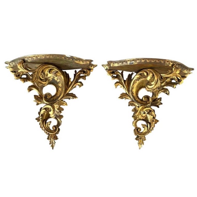 A large Pair of Italian Florentine Wall Brackets, Hand-carved and Giltwood. Each bracket features a serpentine top shelf...