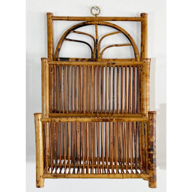 Unique vintage deep pocket rattan magazine rack. Features rich burnt tortoise shell finish. Brass hanging hardware makes...