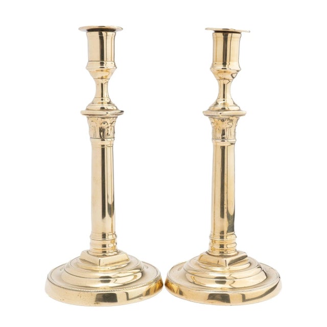 Pair of cast brass columnar candlesticks with Corinthian capitals supporting urn form candle cups. Seam construction with...