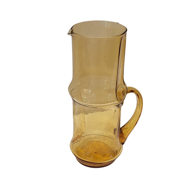 An elegant serving set for water, juice, or soft drinks, made of amber-tinted pressed glass, circa 1960 in Italy. It...