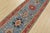 A tribal Caucasian Kazak runner hand-knotted with fine wool on a cotton foundation. This rug features a row of medallions...