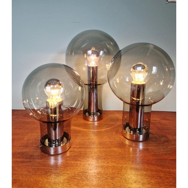 Magnificent trio of chrome-plated metal ceiling lights with smoked glass globes, produced by the dutch manufacturer raak...