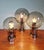 Magnificent trio of chrome-plated metal ceiling lights with smoked glass globes, produced by the dutch manufacturer raak...