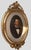 Monumental late 19th-century oil on canvas portrait presented in an elaborate hand-carved wooden Rococo Revival frame with...