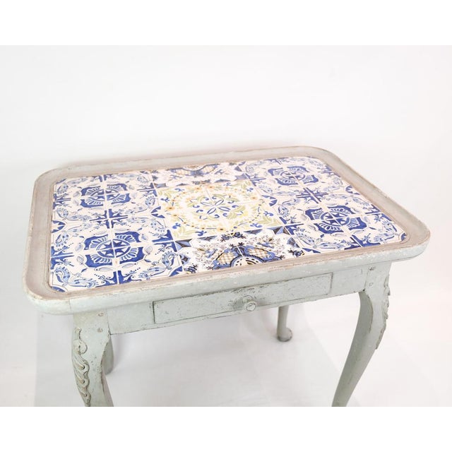 The rococo tile table, painted gray and dated 1780, is a charming example of classic furniture design. Its elegantly...