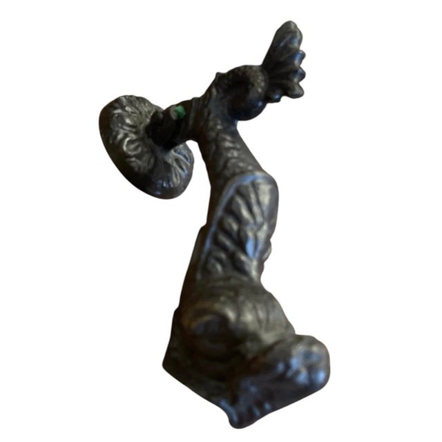 This ornate cast iron door knocker features a classical nautical motif inspired by mythological sea serpents and dolphins...