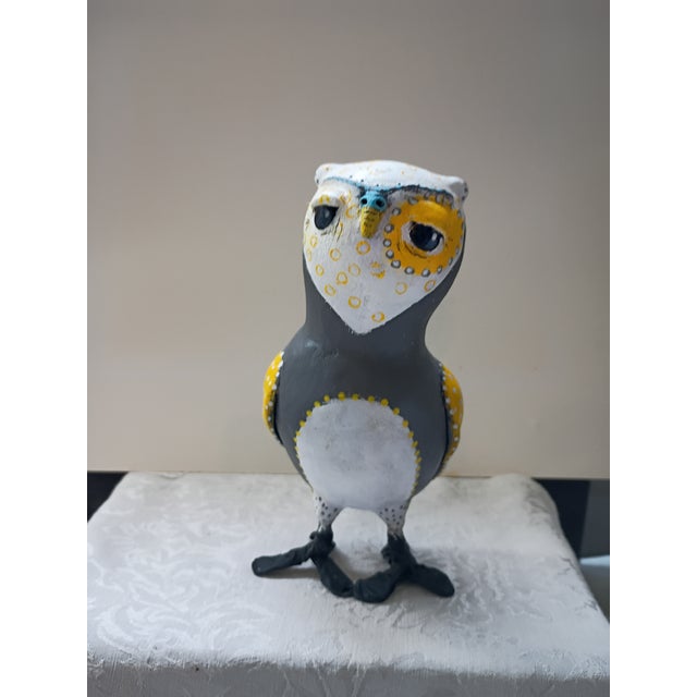 A charming, one-of-a-kind handmade paper mâché owl figurine featuring a bold folk-art aesthetic. The piece showcases a...