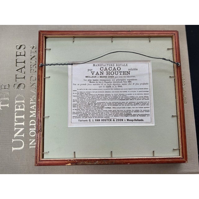 This framed vintage art print features a historic advertisement for Cacao Van Houten, one of the oldest and most renowned...