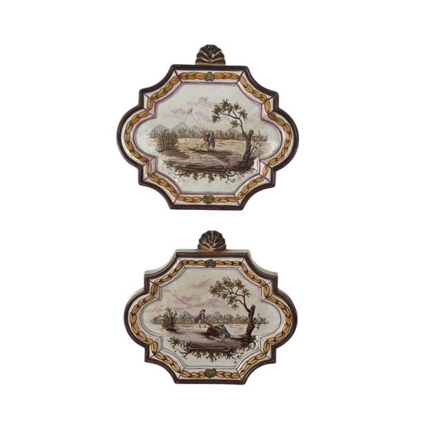 This exceptional pair of 19th-century French tin-glazed earthenware (faience) plaques beautifully captures the Rococo...