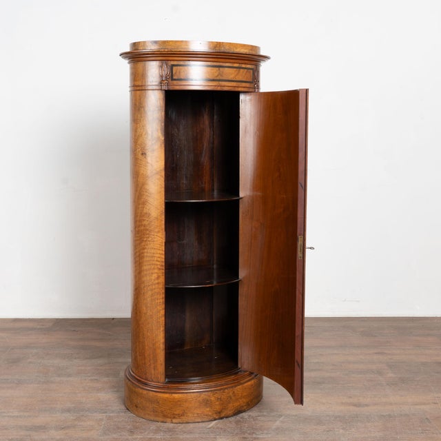 19th century Danish column cabinet crafted with mahogany veneer in a slender cylindrical form. The cabinet features a...