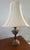Warm vintage brass meets whimsical detail: this elegant table lamp features a gently flared bell shade that casts a soft,...