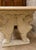A substantial rectangular table in cream-colored stone and light wood, with a monumental and highly decorative character....