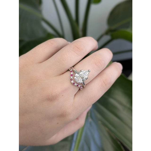 This 14K gold band features eight round rubies (total 0.16 ct, ~1.6 mm each) from Madagascar, complemented by nine...