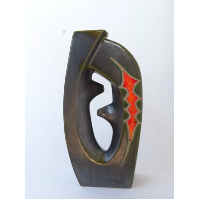 This sculptural vase with two mouths is made of ceramic. It has an abstract decor and irregular shape with polychrome...